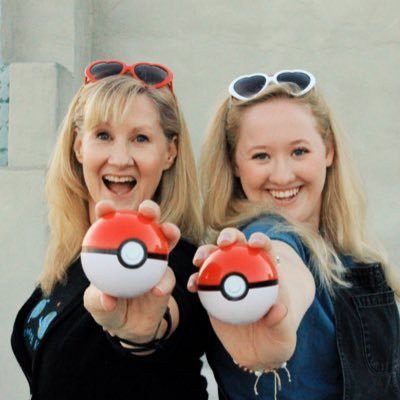 Veronica Taylor Interview: The Voice of Ash on Dubbing, Lip Flap and 25 Years of Pokémon 10 Veronica Taylor and her daughter Rena Taylor, hosts of The Trainer's Guide podcast, standing side-by-side and smiling happily at the camera. Veronica, on the left, has blonde hair with red heart-shaped sunglasses resting on her head, and is holding a red and white Poké Ball out toward the viewer. Rena, on the right, also has blonde hair with white heart-shaped sunglasses on her head, wearing a denim top, and holding out a matching Poké Ball.